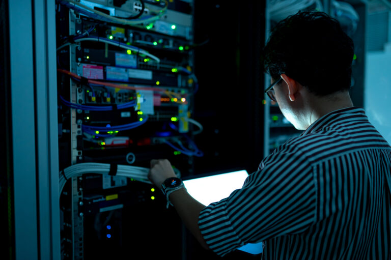Computer engineer is setting up network in server room,Systems Maintenance Technician,Male engineer working in server room at modern data center